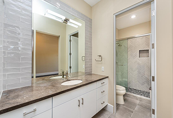 Modern bathroom remodel in San Marino featuring custom vanity and herringbone tile shower